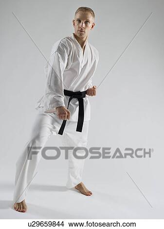 Young man performing karate stance on white background View Large Photo Image Picture - Young man performing karate stance on white background. Fotosearch