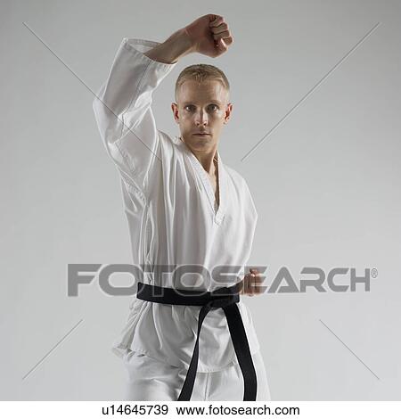 Stock Photo - Young man performing karate stance on white background. Fotosearch