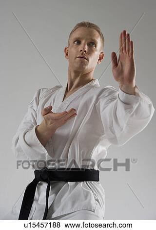 Stock Photo - Young man performing karate stance on white background. Fotosearch