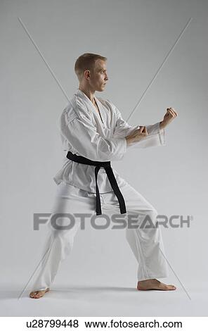 Young man performing karate stance on white background View Large Photo Image Stock Photo - Young man performing karate stance on white background. Fotosearch