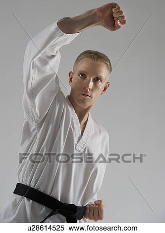 Young man performing karate stance on white background View Large Photo Image Stock Photography - Young man performing karate stance on white background. Fotosearch