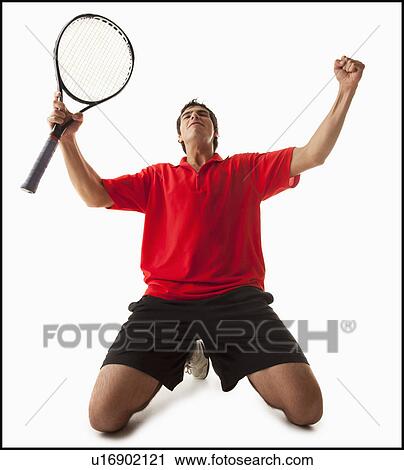 Stock Image - Young man playing tennis winning. Fotosearch