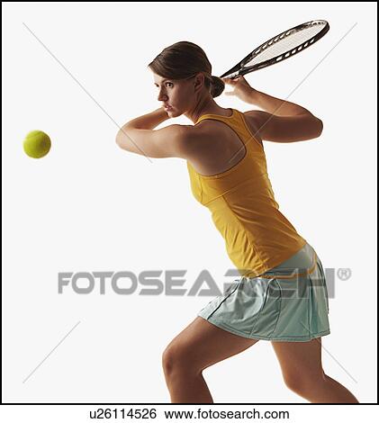 Stock Photograph - Young woman playing tennis. Fotosearch