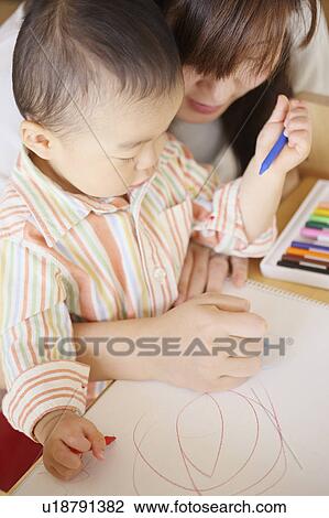 Stock Image - A boy drawing with mother. Fotosearch