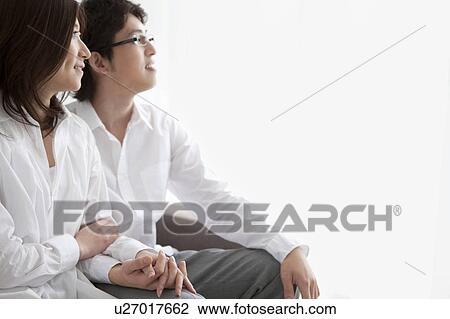 Stock Image - A couple holding hands. Fotosearch