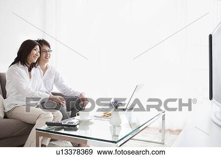 Stock Photo - A couple watching TV. Fotosearch