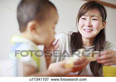 A mother feeding son View Large Photo Image Stock Photo - A mother feeding son. Fotosearch