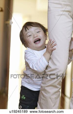 Stock Photo - Baby Girl Holding Mother's Leg. Fotosearch