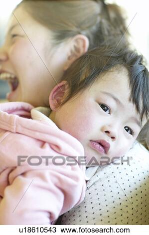 Stock Image - Baby Resting Head on Mother's Shoulder. Fotosearch