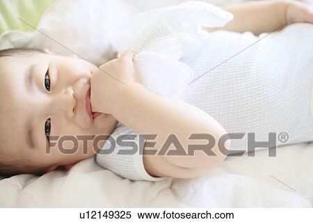 Boy Lying On Back Thumb Sucking Looking At Camera View Large Photo Image Stock Photography - Boy Lying On Back Thumb Sucking Looking At Camera. Fotosearch