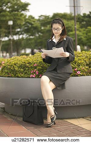 Stock Image - Businesswoman Reading Newspaper. Fotosearch