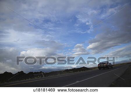 Stock Photo - Clouds Over Country Road. Fotosearch