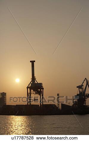Stock Photo - Commercial Dock Crane Architecture Sunrise. Fotosearch
