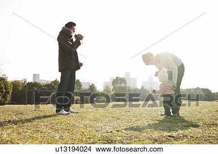 Picture - Family of Three Playing in Park. Fotosearch