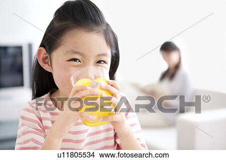 Picture - Girl drinking glass of orange juice. Fotosearch
