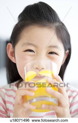 Stock Photograph - Girl drinking glass of orange juice. Fotosearch