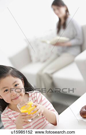 Girl holding glass of orange juice View Large Photo Image Stock Image - Girl holding glass of orange juice. Fotosearch