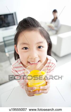 Girl holding glass of orange juice View Large Photo Image Stock Photo - Girl holding glass of orange juice. Fotosearch