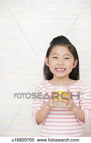 Stock Photography - Girl holding glass of orange juice. Fotosearch