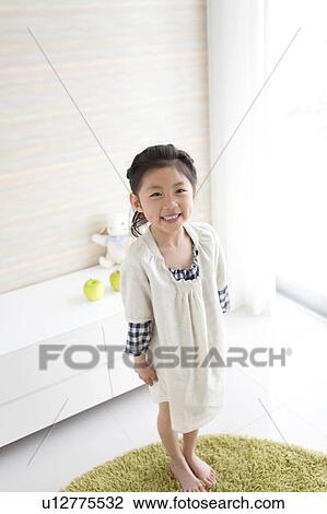 Stock Image - Girl standing and looking at camera. Fotosearch