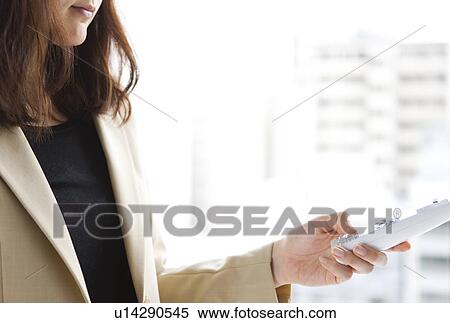 Stock Photography - Hand of woman holding a cordless phone. Fotosearch