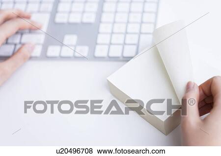 Hand typing and turning a page on a note pad View Large Photo Image Stock Photo - Hand typing and turning a page on a note pad. Fotosearch