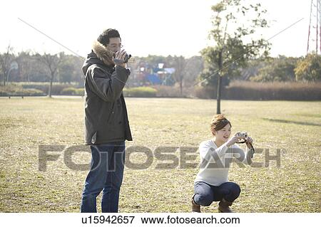 Stock Photo - Mid adult Couple Using Cameras. Fotosearch