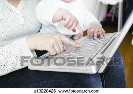 Stock Photograph - Mother and Baby Girl Using Laptop. Fotosearch