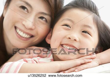 Stock Image - Mother and daughter looking up. Fotosearch