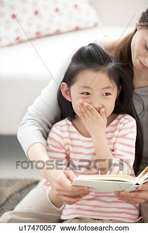 Mother and daughter reading a book together View Large Photo Image Stock Photo - Mother and daughter reading a book together. Fotosearch