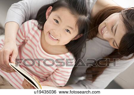 Mother and daughter reading a book together View Large Photo Image Stock Photograph - Mother and daughter reading a book together. Fotosearch