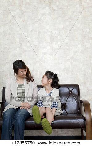 Mother and daughter sitting on sofa View Large Photo Image Stock Image - Mother and daughter sitting on sofa. Fotosearch
