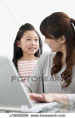 Stock Photo - Mother and daughter using laptop. Fotosearch