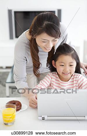 Stock Photo - Mother and daughter using laptop. Fotosearch