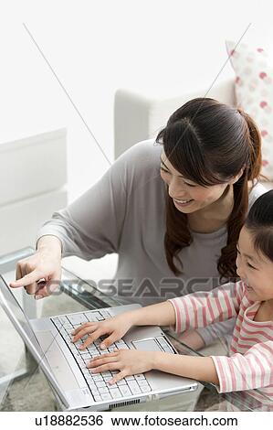 Stock Photograph - Mother and daughter using laptop. Fotosearch