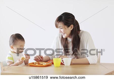Stock Photo - Mother and son eating breakfast. Fotosearch