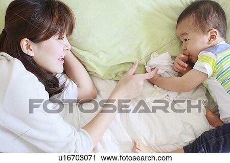 Stock Image - Mother and son laying down. Fotosearch