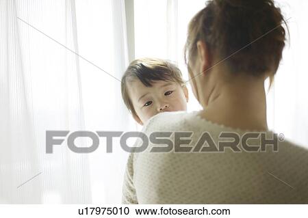 Stock Image - Mother Carrying Daughter. Fotosearch