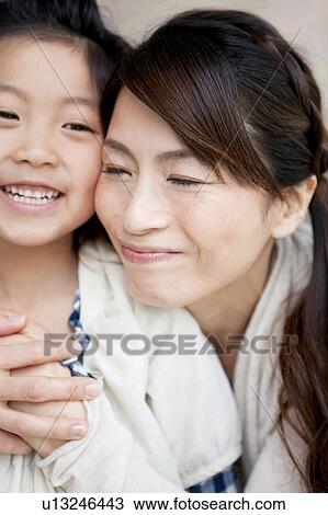 Stock Image - Mother embracing daughter. Fotosearch