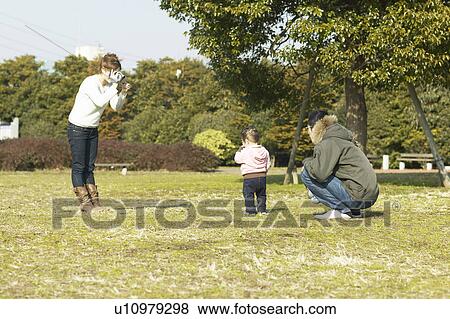 Stock Photo - Mother Filming Father and Daughter. Fotosearch