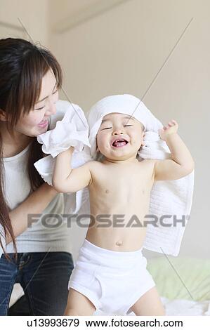 Stock Photo - Mother Son Drying Towel Looking At Camera Smiling. Fotosearch