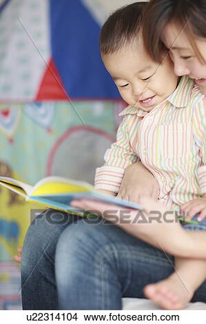 Picture - Mother Son Sitting Reading Book Lap Smiling. Fotosearch