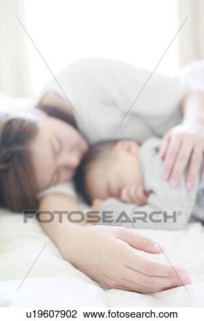 Stock Image - Mother Son Sleeping Next To Lying Down. Fotosearch