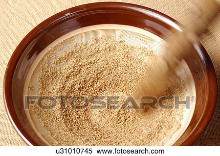 Stock Photography - Sesame Seeds Being Grinded with Pestle and Mortar. Fotosearch