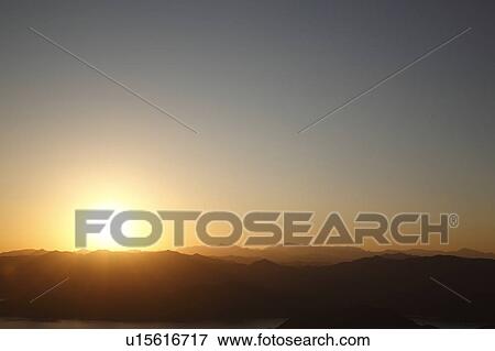 Stock Photo - Sun Setting Over Mountains. Fotosearch