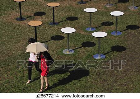 Picture - Two Young Women Walking Past Tables. Fotosearch
