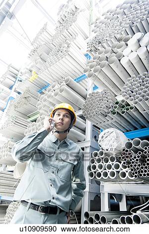 Stock Image - Warehouse Worker on Phone. Fotosearch