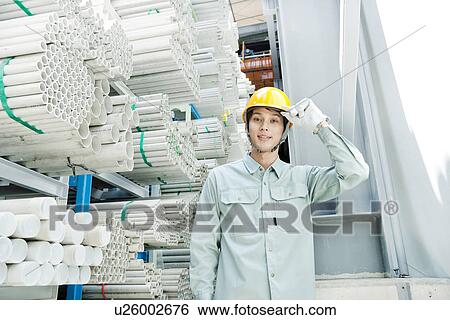 Stock Photograph - Warehouse worker tipping hardhat. Fotosearch
