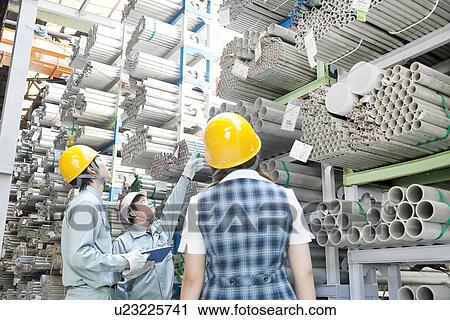 Stock Image - Warehouse Workers Looking at Their Stock. Fotosearch
