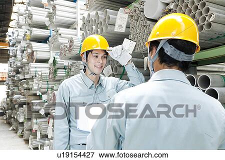 Stock Photo - Warehouse Workers Talking to Each Other. Fotosearch